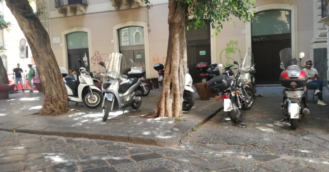 La piazza diventa parcheggio |Via i punkabbestia, ecco gli scooter